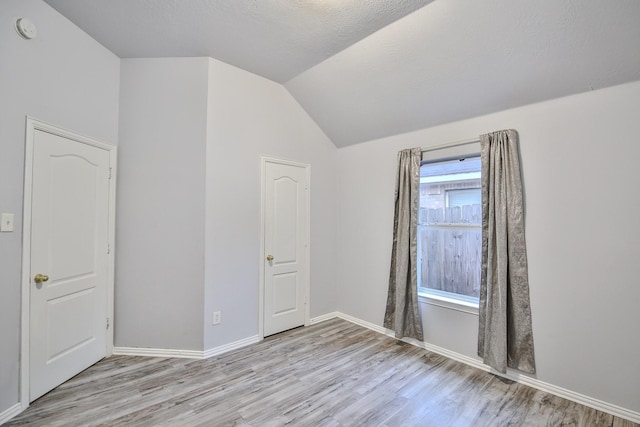 21323 Hannover Frst, Spring, TX 77388 - unfurnished room with light wood-type flooring, lofted ceiling, a smoke detector, and baseboards