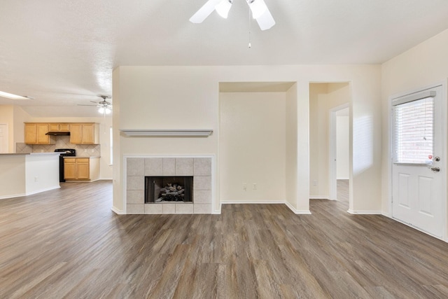 6431 Bright Falls Ln, Katy, TX 77449 - unfurnished living room with a ceiling fan, wood finished floors, baseboards, and a fireplace