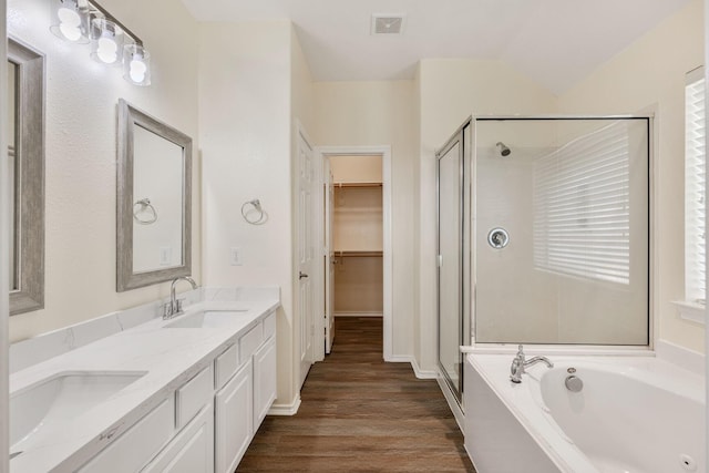 6431 Bright Falls Ln, Katy, TX 77449 - full bathroom with a shower stall, a bath, double vanity, wood finished floors, and a spacious closet