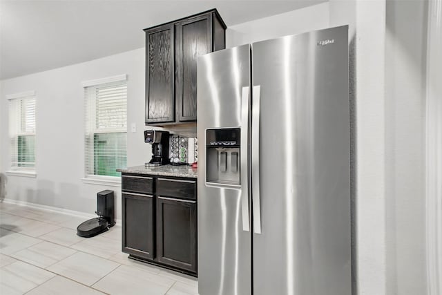 15322 Laceleaf Trl, Houston, TX 77044 - kitchen with stainless steel fridge with ice dispenser, baseboards, light stone counters, and light tile patterned flooring