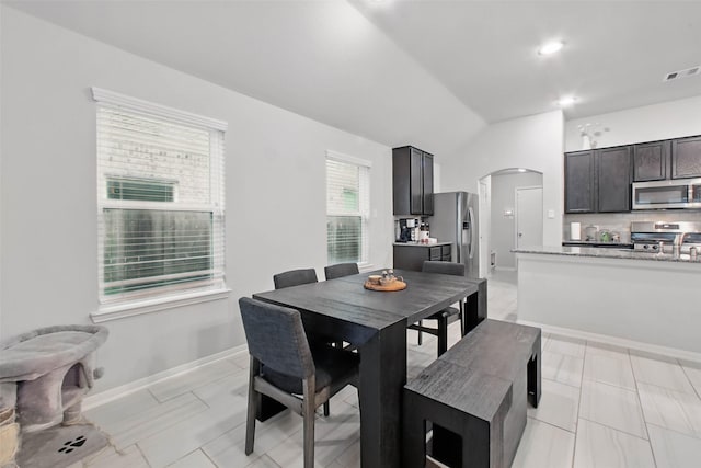 15322 Laceleaf Trl, Houston, TX 77044 - dining space featuring arched walkways, vaulted ceiling, and baseboards