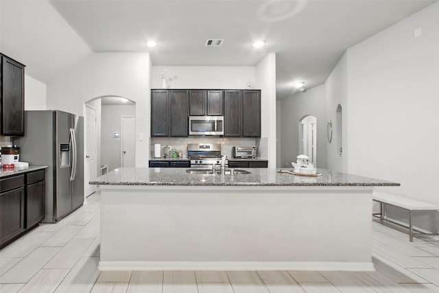 15322 Laceleaf Trl, Houston, TX 77044 - kitchen featuring stainless steel appliances, arched walkways, an island with sink, and a sink