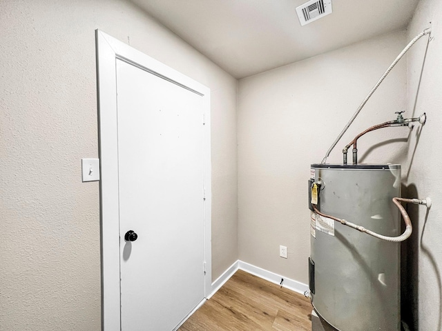 4926 Adonis Dr, Spring, TX 77373 - misc room featuring water heater, light wood-style floors, and baseboards