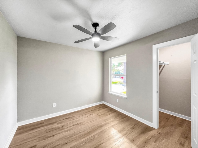 4926 Adonis Dr, Spring, TX 77373 - unfurnished bedroom featuring wood finished floors, a walk in closet, and baseboards