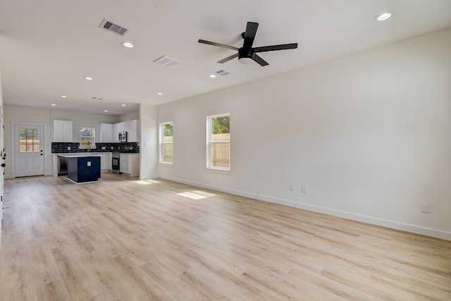 8149 Talton St B, Unit A, Houston, TX 77028 - unfurnished living room featuring light wood-style floors, recessed lighting, baseboards, a ceiling fan, and a sink
