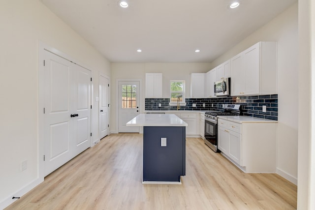8149 Talton St B, Unit A, Houston, TX 77028 - kitchen featuring appliances with stainless steel finishes, tasteful backsplash, light wood finished floors, white cabinetry, and recessed lighting