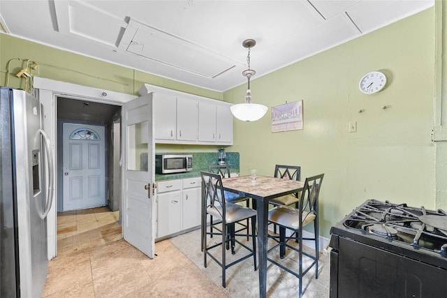 7815 Dayton St, Houston, TX 77012 - kitchen with stainless steel appliances, white cabinetry, and decorative light fixtures