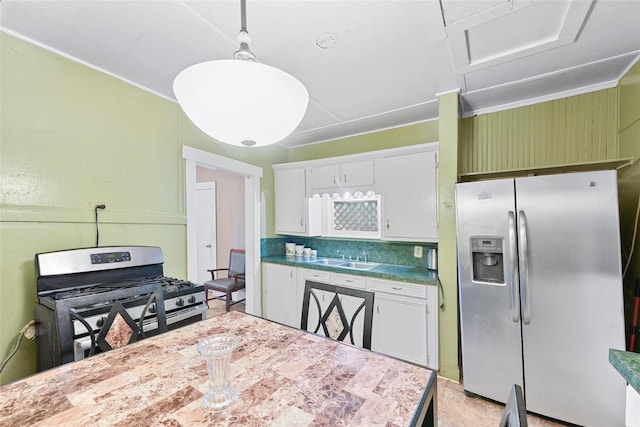 7815 Dayton St, Houston, TX 77012 - kitchen with appliances with stainless steel finishes, white cabinetry, decorative backsplash, a sink, and hanging light fixtures