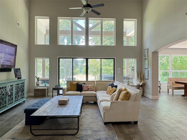 201 Deen Dr, Houston, TX 77336 - living area with a towering ceiling, a ceiling fan, arched walkways, baseboards, and wood finished floors
