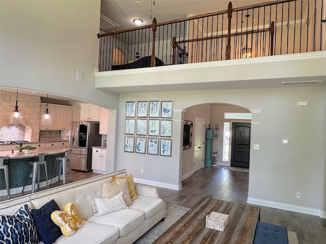 201 Deen Dr, Houston, TX 77336 - living room featuring arched walkways, baseboards, dark wood-style flooring, and a high ceiling