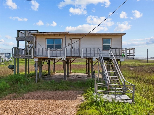 227 Detenbeck Ave, Surfside Beach, TX 77541 - rear view of property featuring a wooden deck, stairs, and a carport