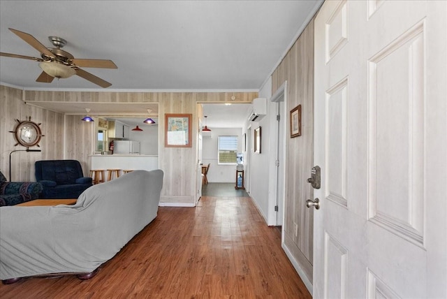 227 Detenbeck Ave, Surfside Beach, TX 77541 - living room featuring wood finished floors, a ceiling fan, ornamental molding, baseboards, and wooden walls