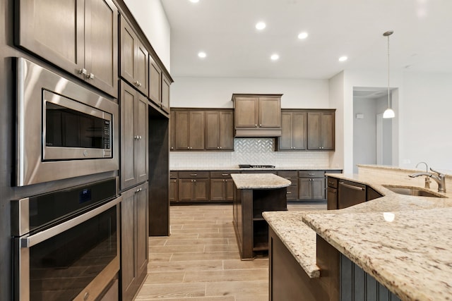 5204 Andorra Bend Ln, Porter, TX 77365 - kitchen with a sink, appliances with stainless steel finishes, light wood-style flooring, decorative backsplash, and recessed lighting