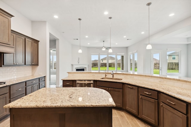 5204 Andorra Bend Ln, Porter, TX 77365 - kitchen with a sink, a ceiling fan, decorative backsplash, a kitchen island, and dishwasher