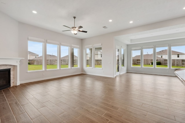 5204 Andorra Bend Ln, Porter, TX 77365 - unfurnished living room with a ceiling fan, wood finished floors, a glass covered fireplace, recessed lighting, and baseboards