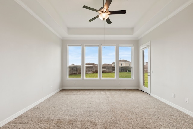 5204 Andorra Bend Ln, Porter, TX 77365 - spare room featuring a tray ceiling, light carpet, a ceiling fan, and baseboards