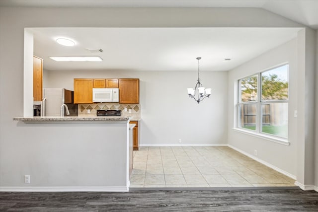 10410 Caribou Cv, Missouri City, TX 77459 - kitchen featuring white appliances, brown cabinets, backsplash, a chandelier, and hanging light fixtures