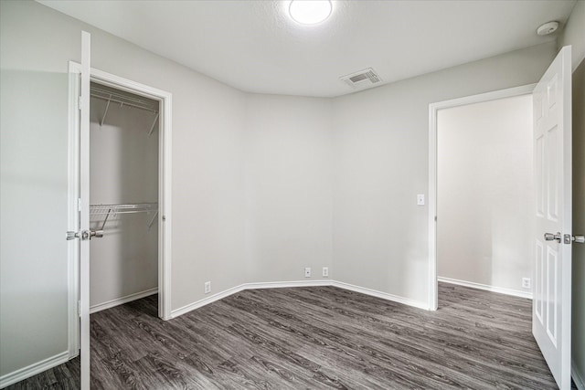 10410 Caribou Cv, Missouri City, TX 77459 - unfurnished bedroom with dark wood-style flooring, a closet, and baseboards