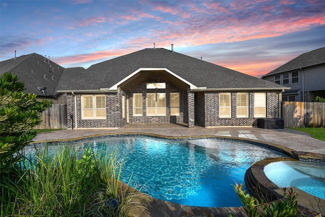 17218 Meek Pass Dr, Cypress, TX 77433 - pool at dusk featuring a patio and a pool with connected hot tub