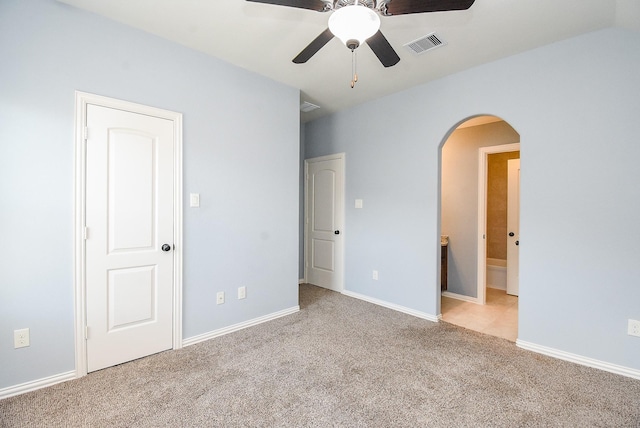 17218 Meek Pass Dr, Cypress, TX 77433 - unfurnished bedroom with arched walkways, carpet flooring, baseboards, connected bathroom, and a ceiling fan