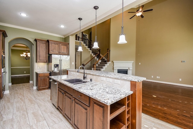 17218 Meek Pass Dr, Cypress, TX 77433 - kitchen featuring stainless steel appliances, a sink, an island with sink, ornamental molding, and open shelves