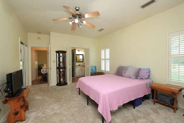 23302 Green Forest St, Hockley, TX 77447 - carpeted bedroom with multiple windows, a ceiling fan, and connected bathroom