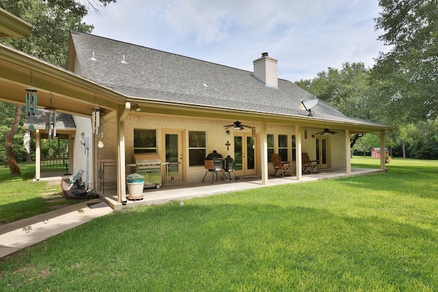 23302 Green Forest St, Hockley, TX 77447 - rear view of house featuring ceiling fan, a lawn, a shingled roof, brick siding, and a patio