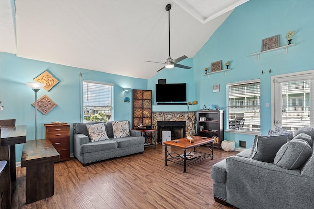 16703 Managua Way, Jamaica Beach, TX 77554 - living area with a fireplace, ceiling fan, wood finished floors, healthy amount of natural light, and high vaulted ceiling