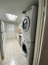 12633 Memorial Dr Unit 72, Houston, TX 77024 - laundry area featuring estacked washer and dryer and light tile patterned floors
