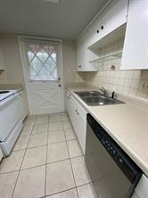 12633 Memorial Dr Unit 72, Houston, TX 77024 - kitchen featuring stainless steel dishwasher, light tile patterned flooring, a sink, and light countertops