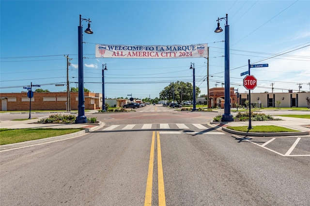 1309 1st St, La Marque, TX 77568 - view of asphalt street featuring traffic signs, street lighting, curbs, and sidewalks