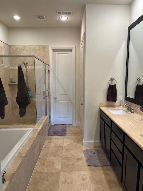 2533 Lamar St, Houston, TX 77003 - bathroom featuring a stall shower, double vanity, tiled tub, and baseboards