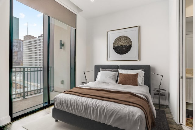 1211 Caroline St Unit 906, Houston, TX 77002 - bedroom with wood finished floors, multiple windows, and access to outside