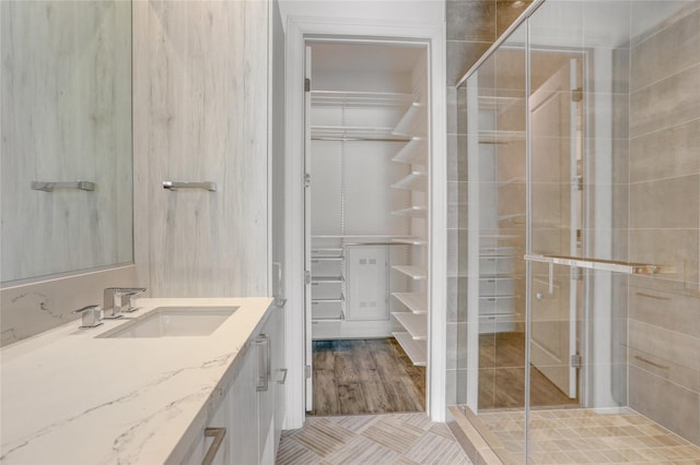 1211 Caroline St Unit 906, Houston, TX 77002 - bathroom with vanity, a spacious closet, a stall shower, and tile patterned flooring
