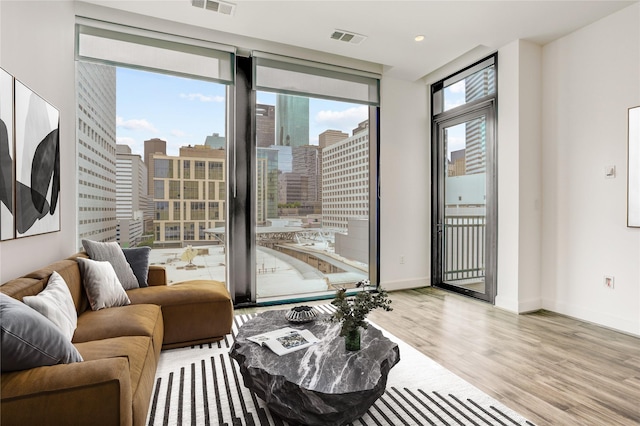 1211 Caroline St Unit 906, Houston, TX 77002 - living area featuring wood finished floors, plenty of natural light, a view of city, and baseboards