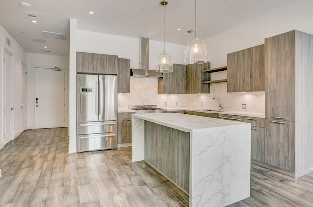 1211 Caroline St Unit 906, Houston, TX 77002 - kitchen with stainless steel appliances, modern cabinets, wall chimney exhaust hood, decorative backsplash, and a kitchen island