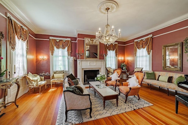 301 S Alexander Ave, Washington, GA 30673 - living room featuring light wood-style floors, healthy amount of natural light, a chandelier, ornamental molding, and a fireplace with flush hearth