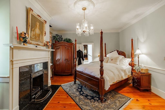 301 S Alexander Ave, Washington, GA 30673 - bedroom featuring a chandelier, a fireplace, light wood-style floors, and crown molding