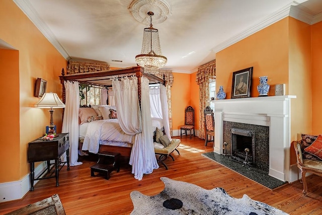 301 S Alexander Ave, Washington, GA 30673 - bedroom with multiple windows, a chandelier, crown molding, hardwood / wood-style floors, and a high end fireplace