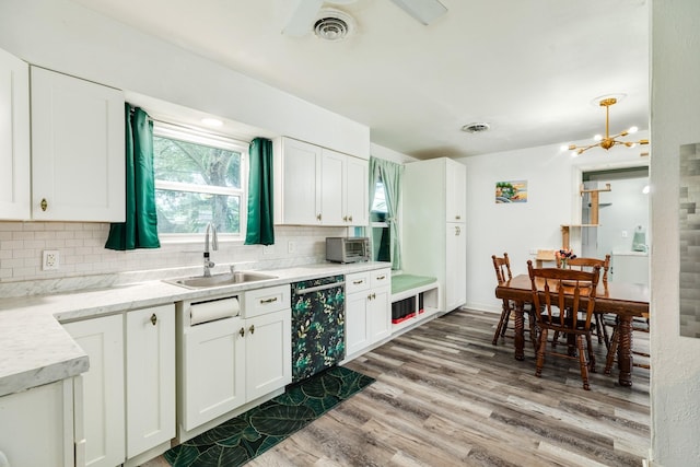 117 Tuna St, Galveston, TX 77550 - kitchen featuring dishwasher, tasteful backsplash, wood finished floors, white cabinetry, and a chandelier