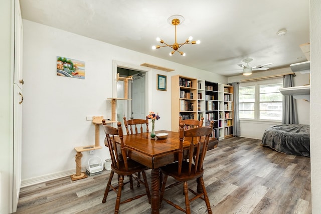 117 Tuna St, Galveston, TX 77550 - dining area featuring wood finished floors, a chandelier, and a ceiling fan
