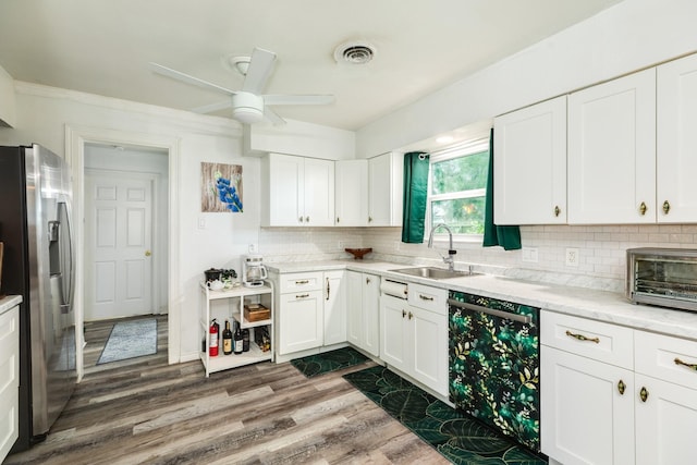 117 Tuna St, Galveston, TX 77550 - kitchen featuring stainless steel refrigerator with ice dispenser, dishwasher, decorative backsplash, and white cabinets