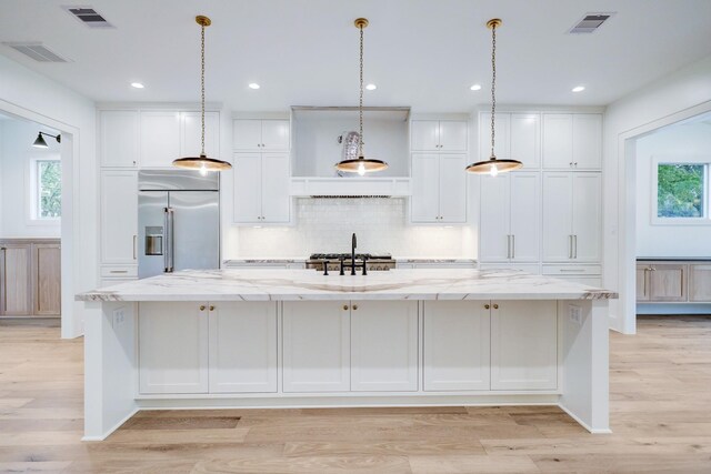 1438 Wakefield Dr, Houston, TX 77018 - kitchen featuring stainless steel built in refrigerator, white cabinets, a spacious island, light wood finished floors, and recessed lighting