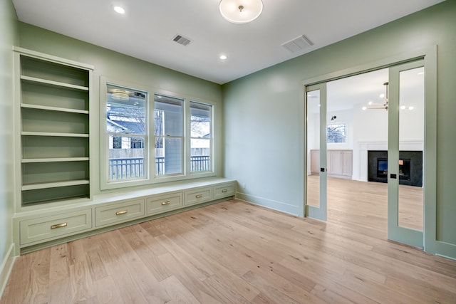 1438 Wakefield Dr, Houston, TX 77018 - unfurnished room featuring light wood-style flooring, a glass covered fireplace, baseboards, and recessed lighting