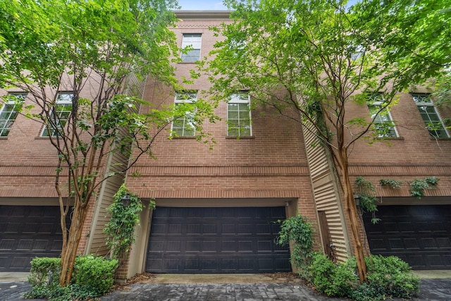 1807 Ashland St, Houston, TX 77008 - back of property with driveway, an attached garage, and brick siding