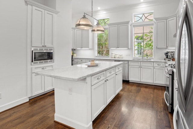 1807 Ashland St, Houston, TX 77008 - kitchen featuring stainless steel appliances, dark wood-style flooring, white cabinets, a kitchen island, and ornamental molding