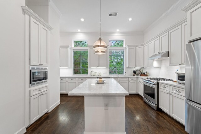 1807 Ashland St, Houston, TX 77008 - kitchen with appliances with stainless steel finishes, a sink, under cabinet range hood, a kitchen island, and backsplash