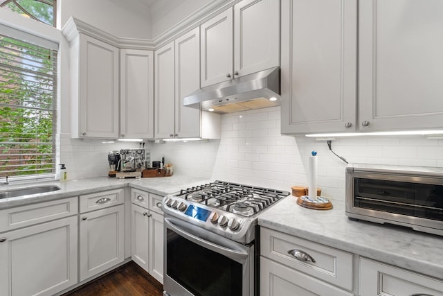 1807 Ashland St, Houston, TX 77008 - kitchen with stainless steel range with gas cooktop, under cabinet range hood, backsplash, white cabinetry, and light stone counters