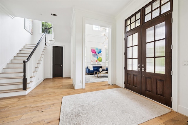 5420 Maple St, Bellaire, TX 77401 - foyer with french doors, light wood-style flooring, stairway, ornamental molding, and baseboards