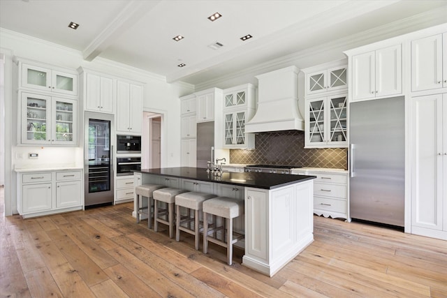 5420 Maple St, Bellaire, TX 77401 - kitchen featuring stainless steel appliances, ornamental molding, tasteful backsplash, premium range hood, and light wood-style floors